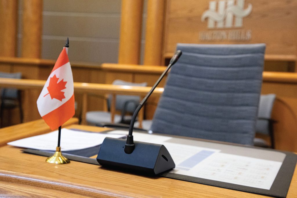 Halton Hills council chamber microphone and Canadian flag at the council table